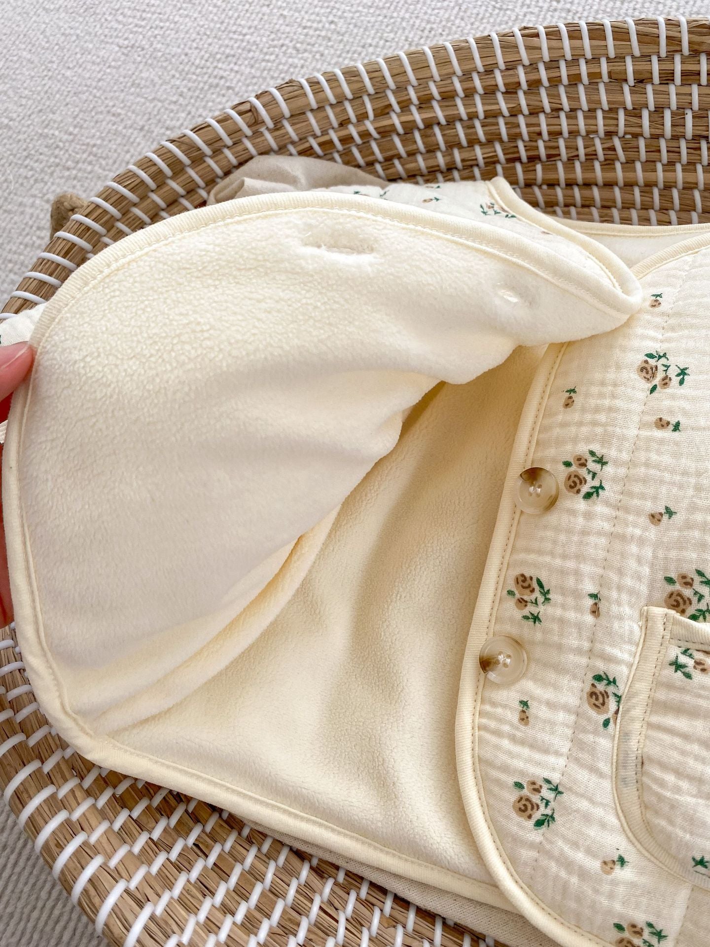 Cream baby blanket with floral pattern.