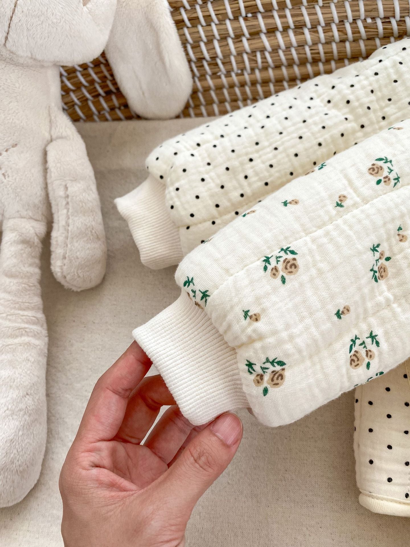 Hand holding baby quilted pajamas.