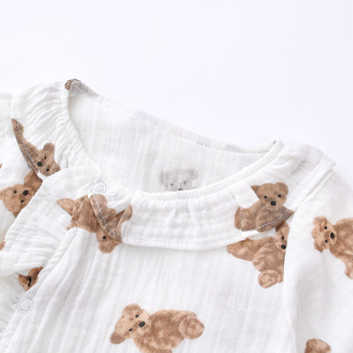 Baby girls' romper featuring bear print pattern and lace design, round collar, and long sleeves, perfect for stylish infants.