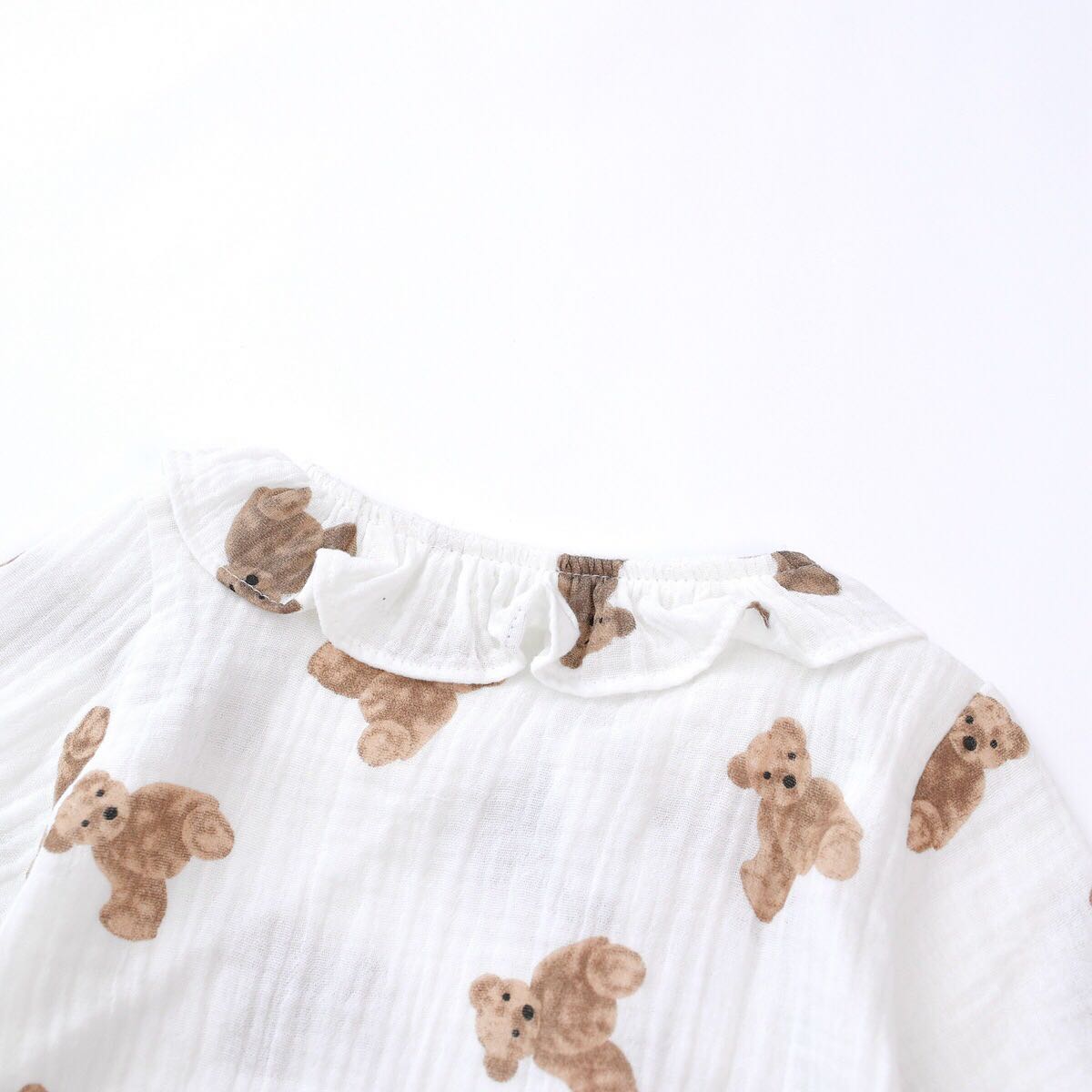 Baby girls' romper featuring bear print pattern and lace design, round collar, and long sleeves, perfect for stylish infants.