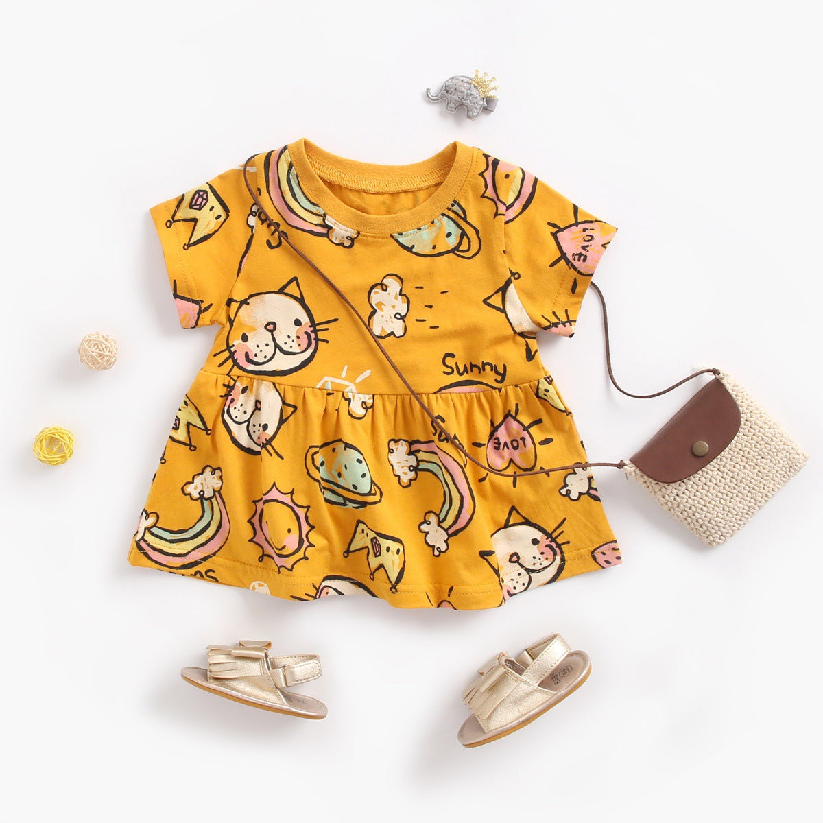A bright yellow baby girl's dress featuring a cartoon print with animals and rainbows, perfect for summer wear.