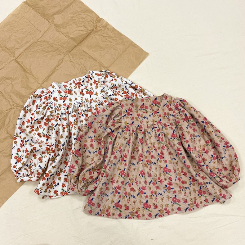 Baby girls floral pattern puff sleeved square-neck top in white and red, showcasing a playful design perfect for any occasion.