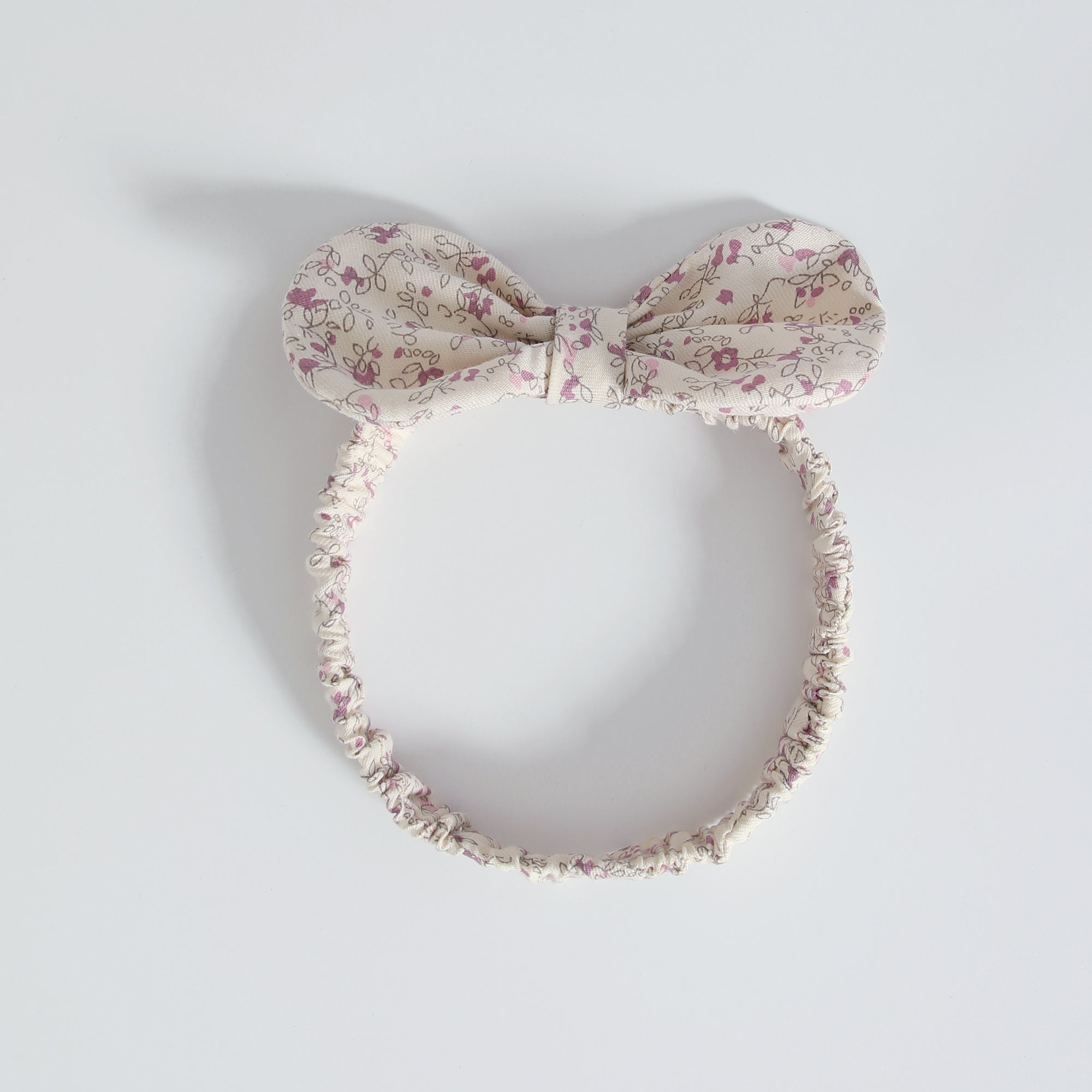 Baby girl wearing a floral print doll collar onesie with a matching headband, showcasing a stylish summer outfit.