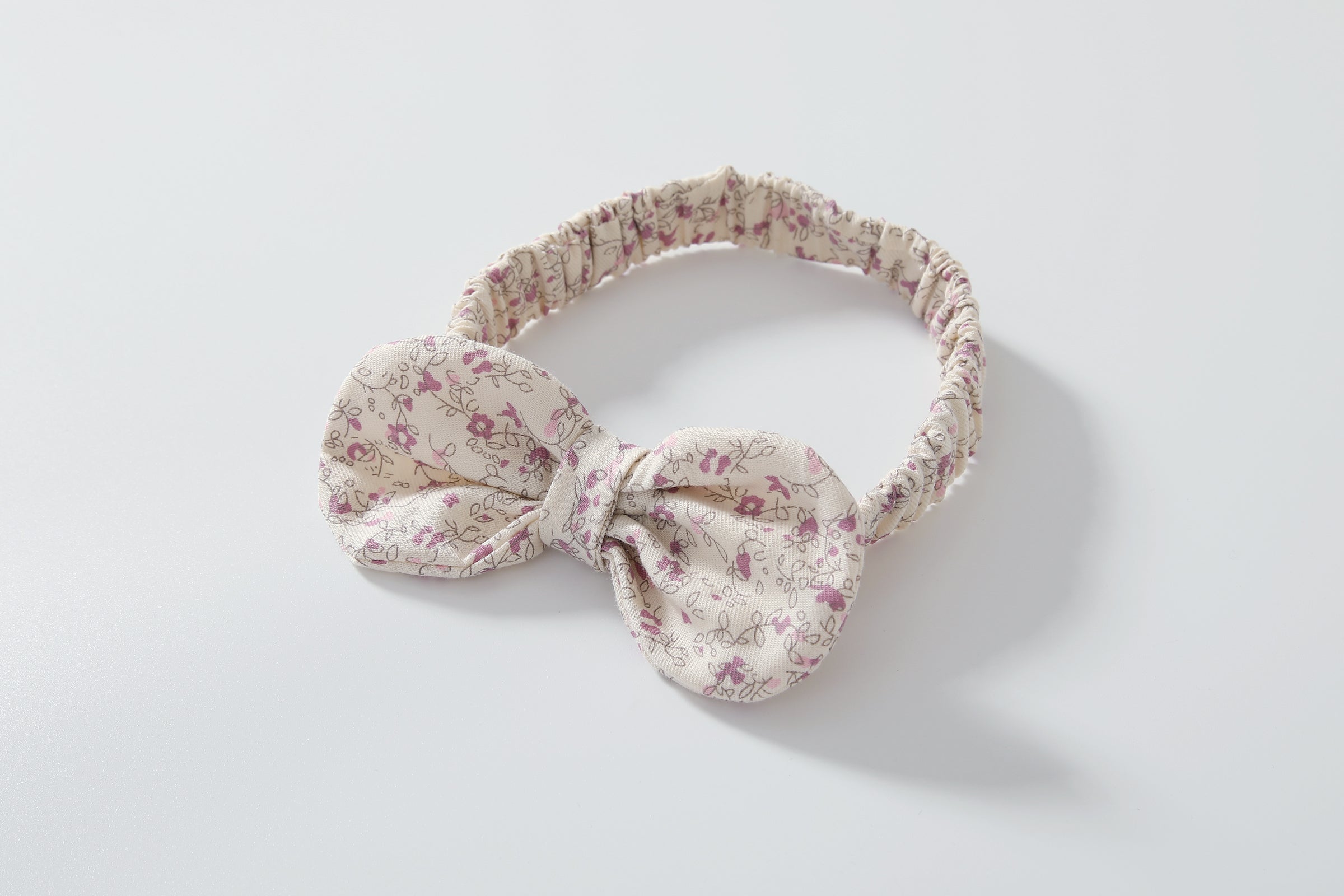 Baby girl wearing a floral print doll collar onesie with a matching headband, showcasing a stylish summer outfit.