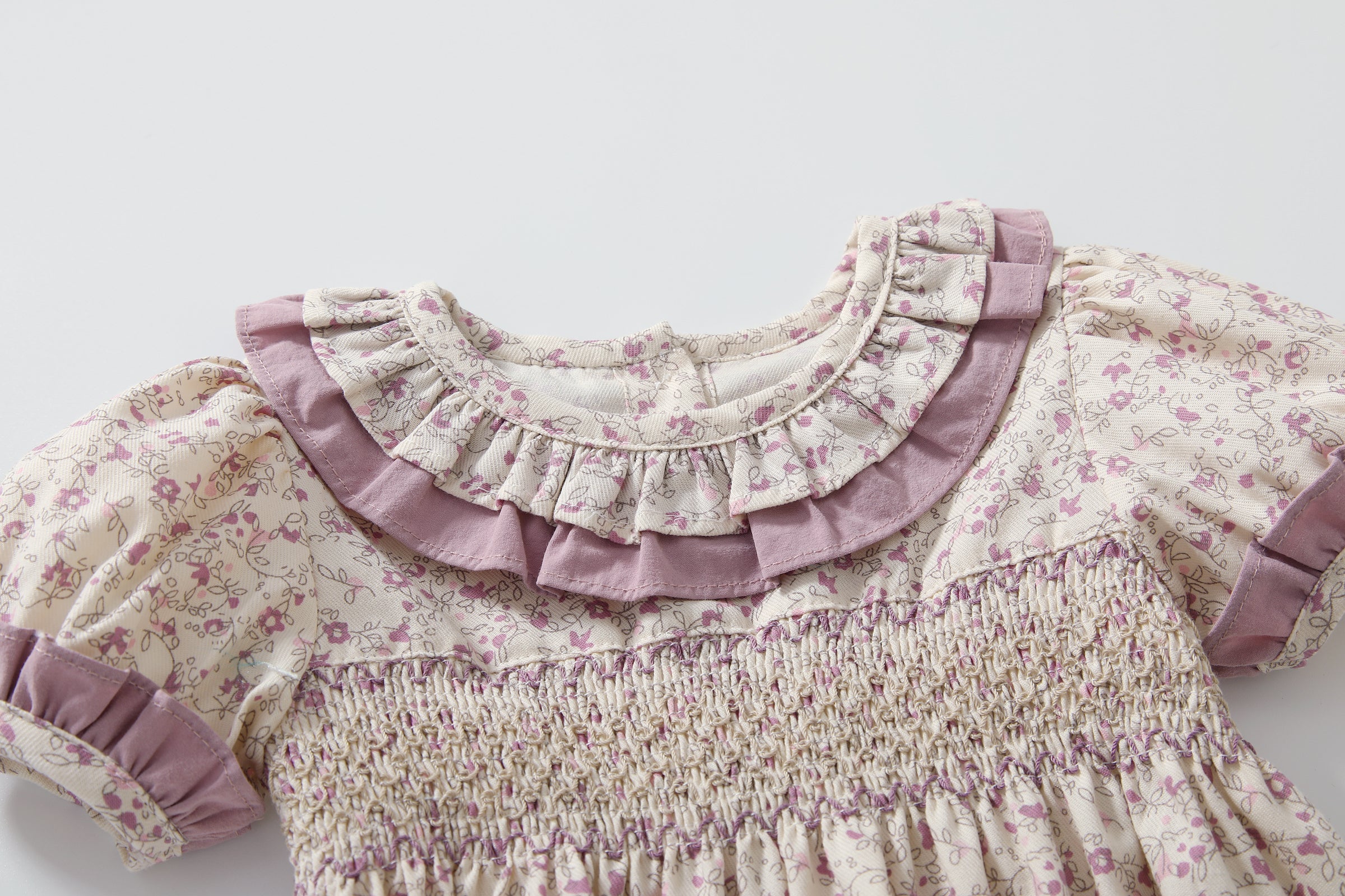 Baby girl wearing a floral print doll collar onesie with a matching headband, showcasing a stylish summer outfit.