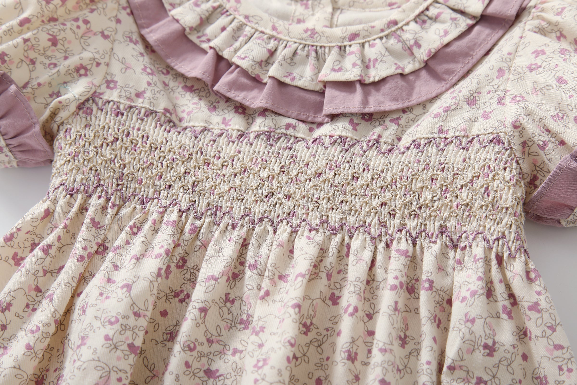 Baby girl wearing a floral print doll collar onesie with a matching headband, showcasing a stylish summer outfit.