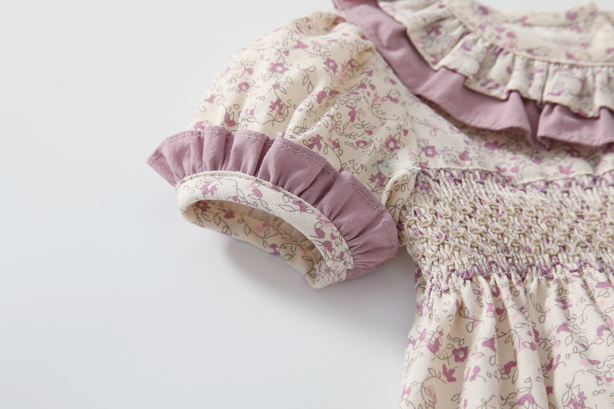 Baby girl wearing a floral print doll collar onesie with a matching headband, showcasing a stylish summer outfit.