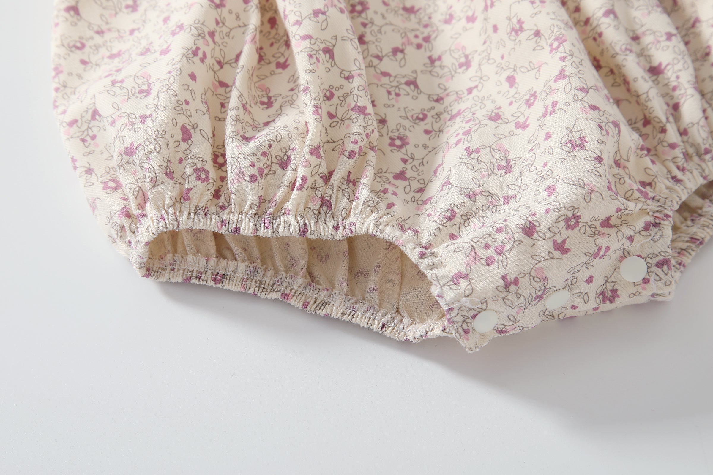 Baby girl wearing a floral print doll collar onesie with a matching headband, showcasing a stylish summer outfit.