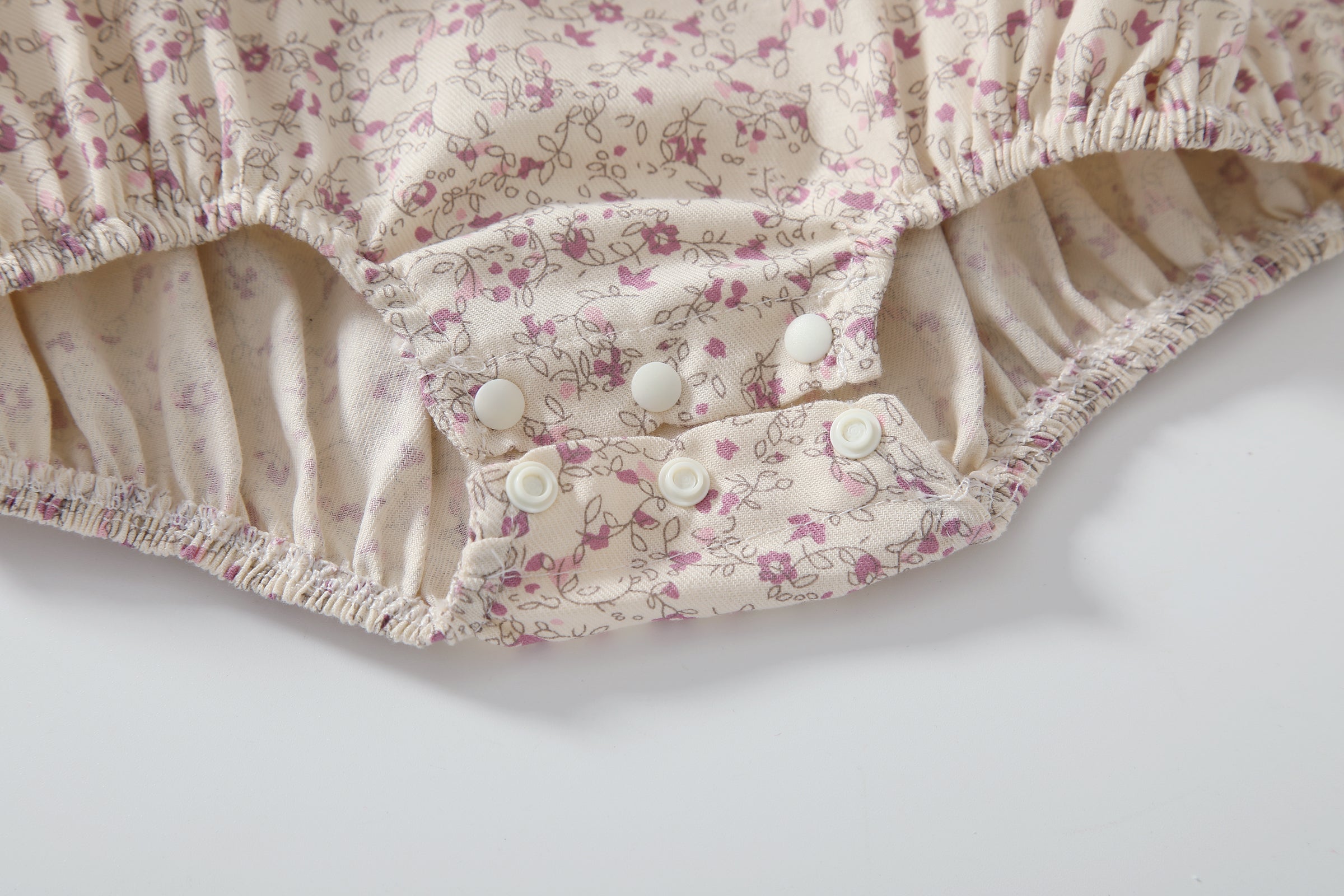 Baby girl wearing a floral print doll collar onesie with a matching headband, showcasing a stylish summer outfit.