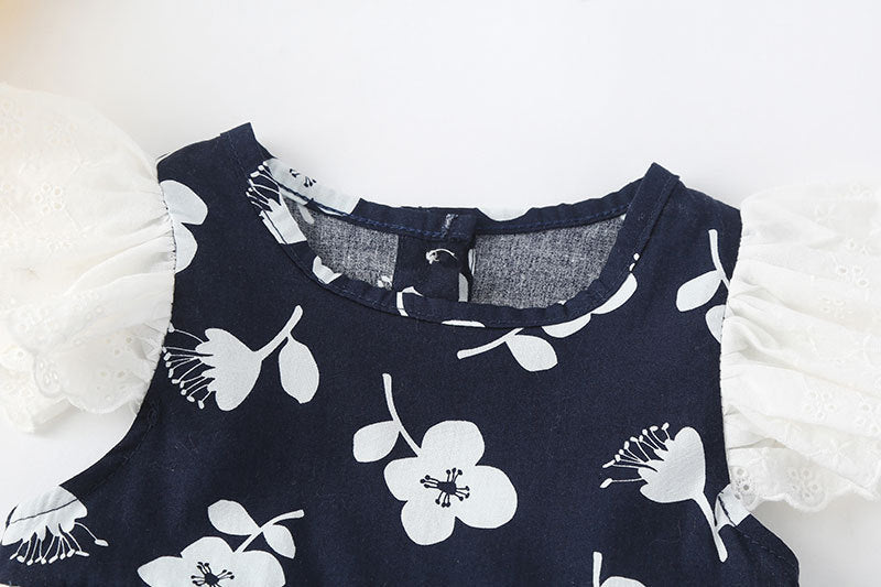 A cute baby girl wearing a floral print sleeveless dress, showcasing a vibrant design with an O-neck and single-breasted style, perfect for summer.