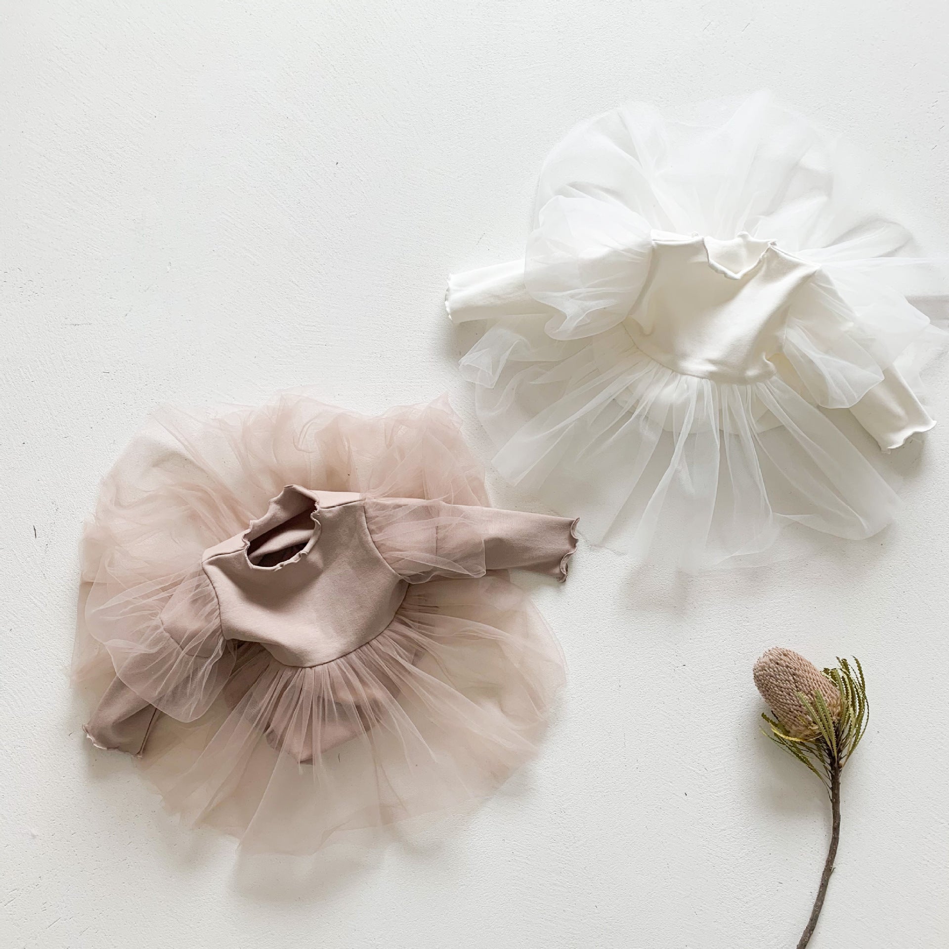 Baby girls' lace patchwork bubble dress in white with long sleeves, showcasing delicate lace details and a comfortable fit.