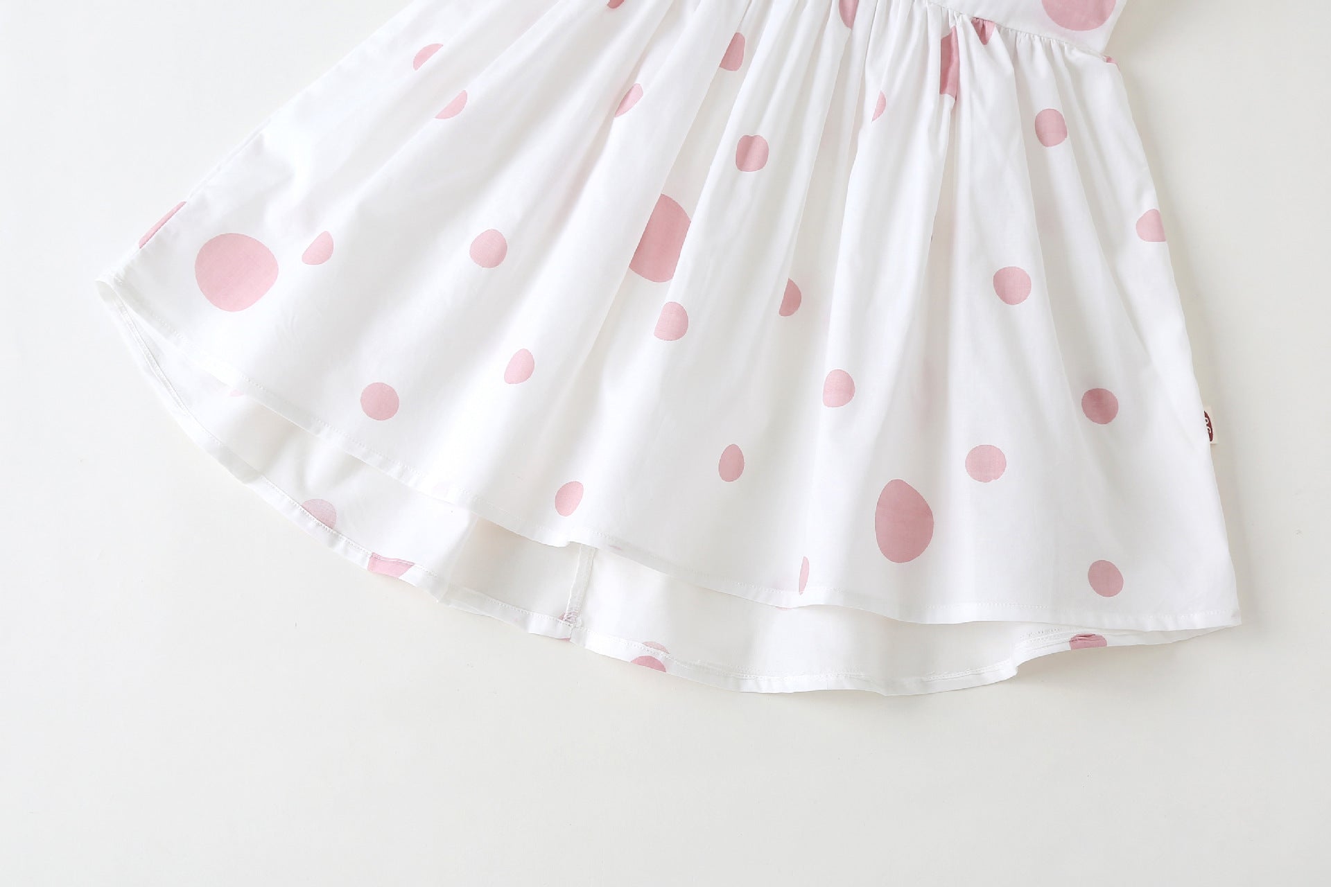 Baby girls' sleeveless dress featuring a polka dot pattern and a bow, available in pink, green, and yellow.