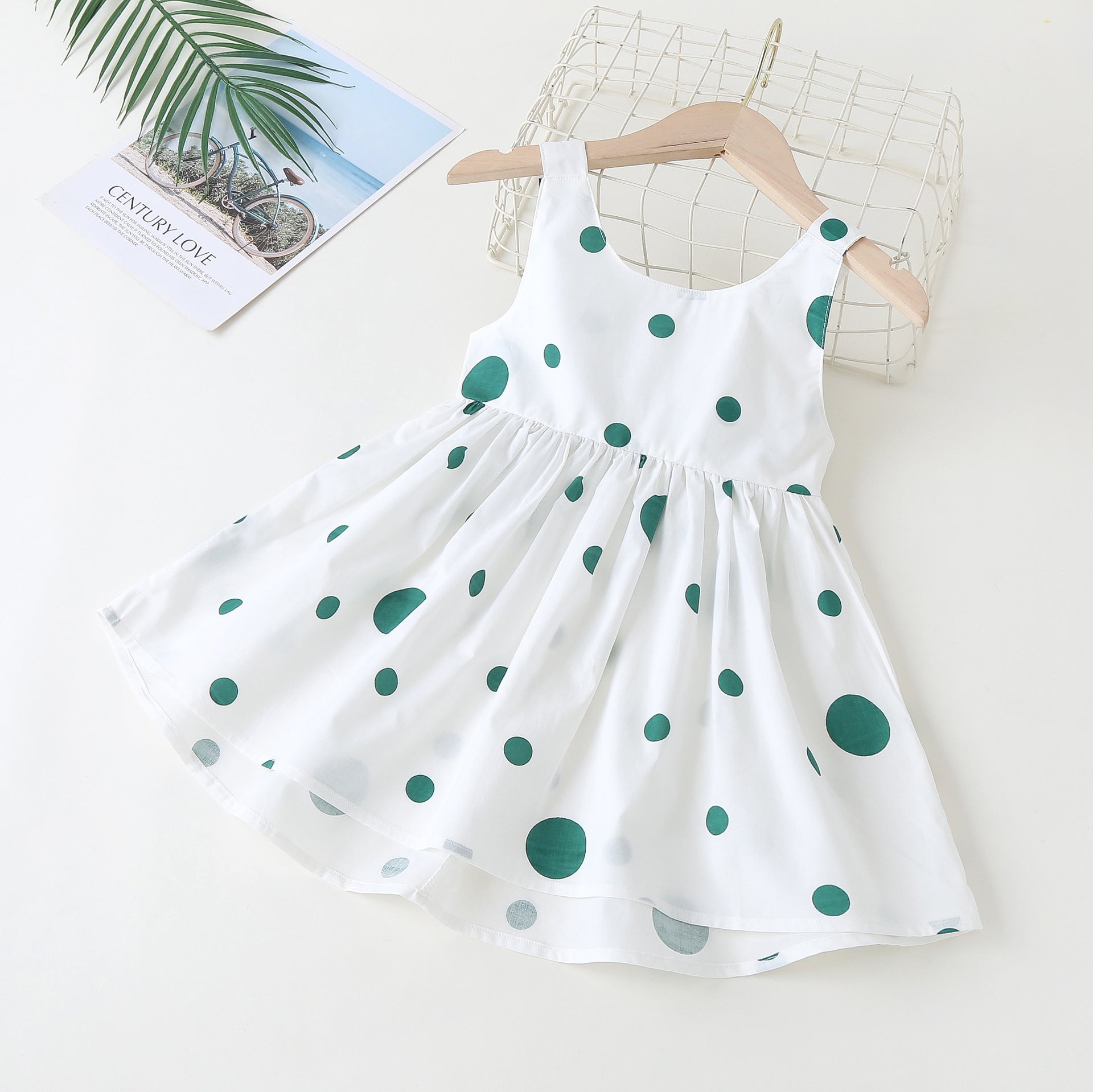 Baby girls' sleeveless dress featuring a polka dot pattern and a bow, available in pink, green, and yellow.