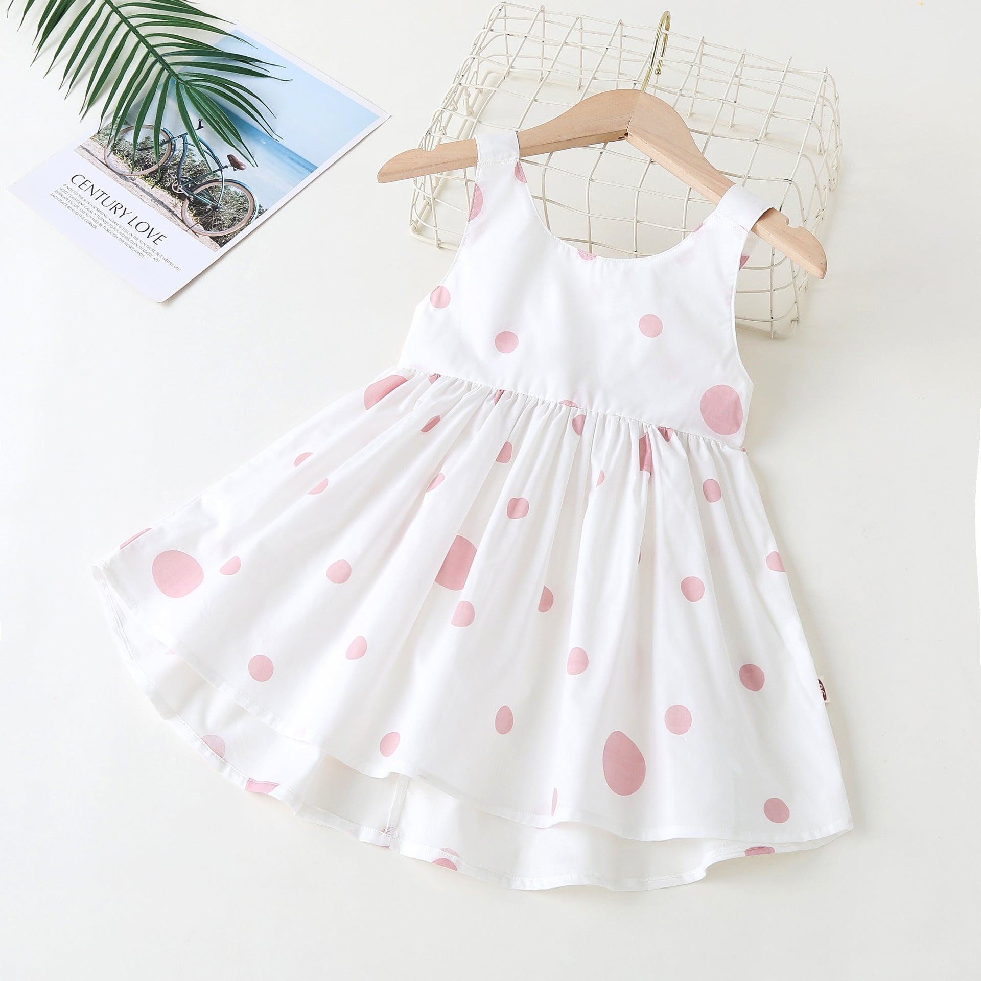Baby girls' sleeveless dress featuring a polka dot pattern and a bow, available in pink, green, and yellow.