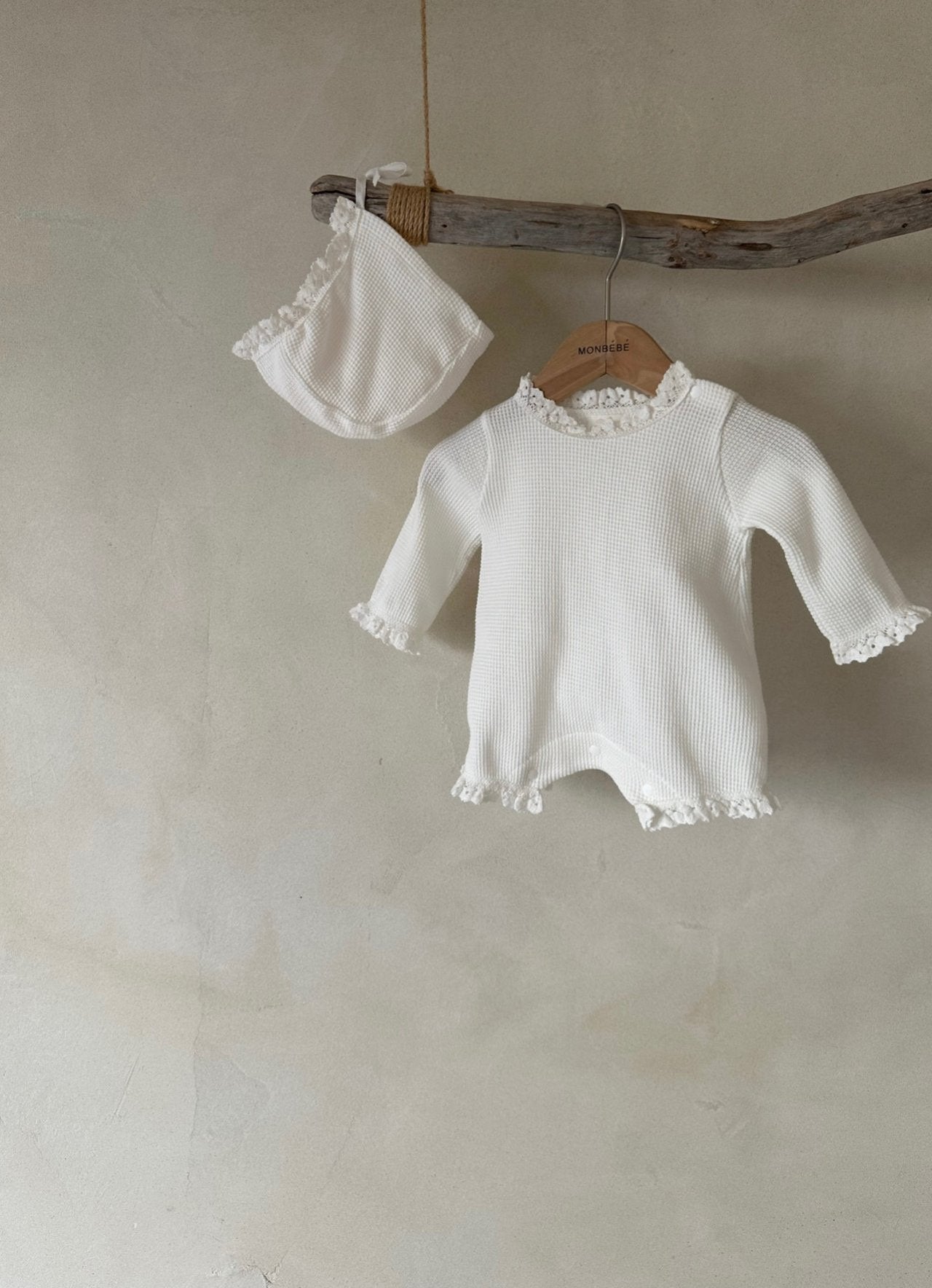 Baby girls' long sleeves onesie in waffle design with lace collar, available in white and apricot colors.