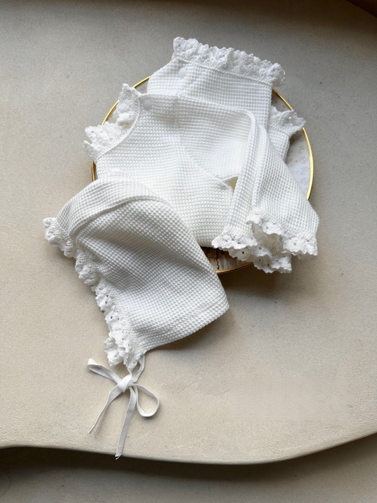 Baby girls' long sleeves onesie in waffle design with lace collar, available in white and apricot colors.