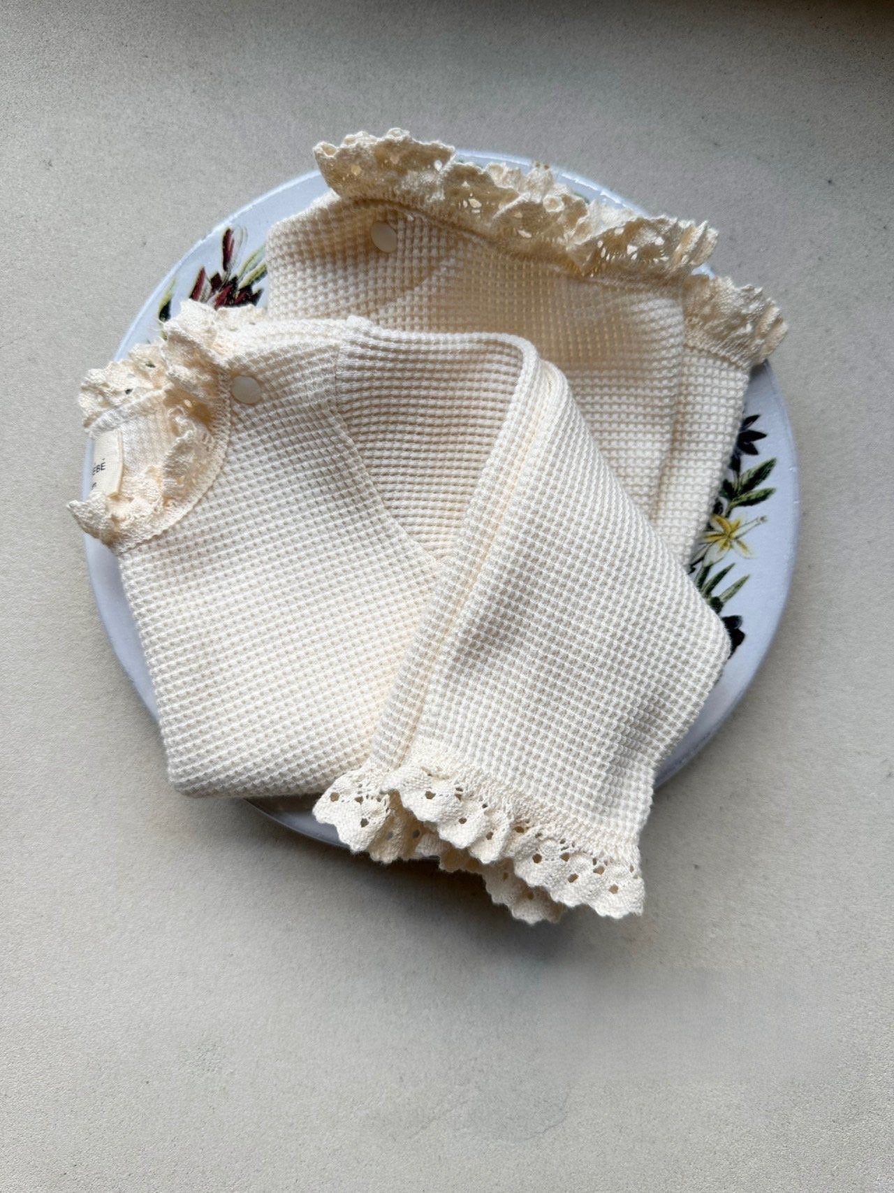 Baby girls' long sleeves onesie in waffle design with lace collar, available in white and apricot colors.