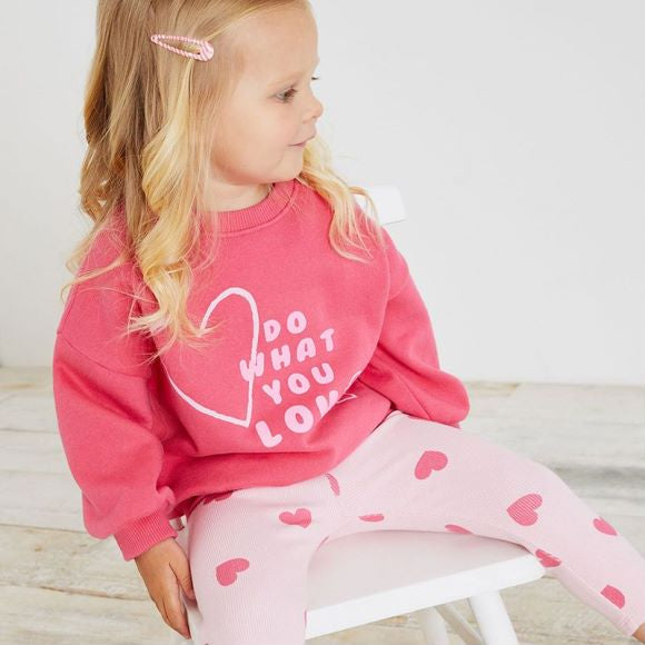 A pink baby hoodie set featuring a heart print pattern, perfect for girls aged 12 months to 10 years.