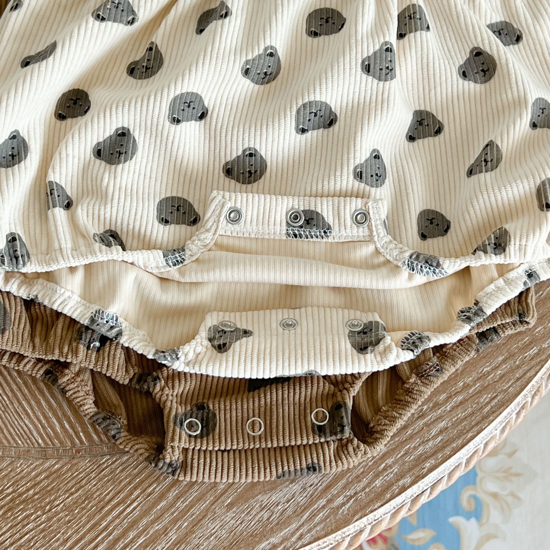 Baby Heart Print Pattern Strap Design Triangle Onesies in beige and brown, showcasing intricate heart patterns and stylish straps.