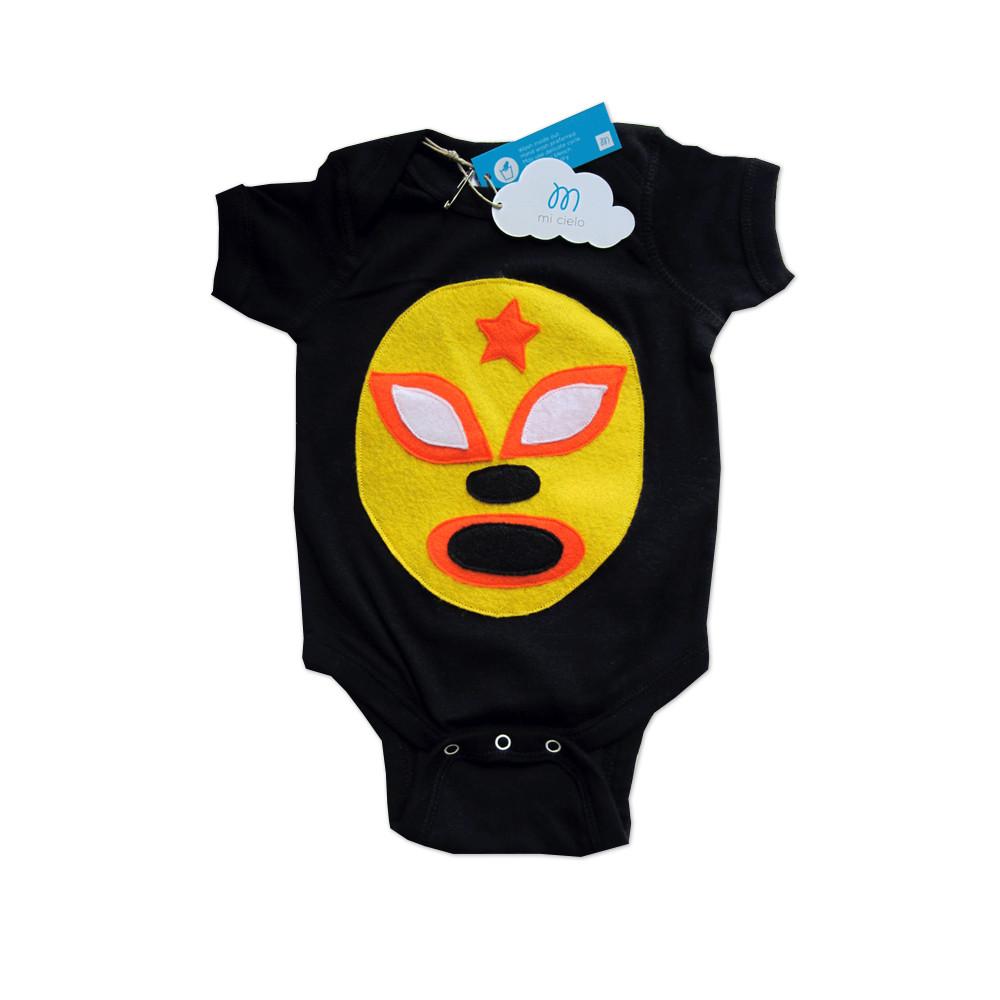 A vibrant yellow baby onesie featuring a luchador mask design, handmade with love and care, perfect for infants.