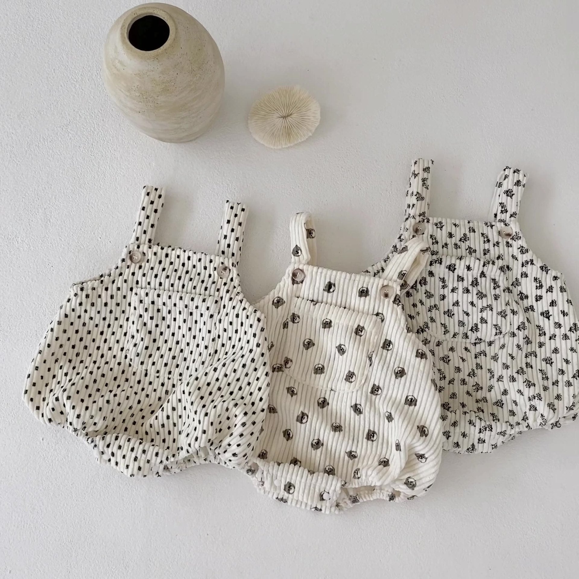 A collection of Baby Print Pattern Vintage Style Cute Strap Onesies in beige, apricot, and brown with floral, animal, and cartoon designs.