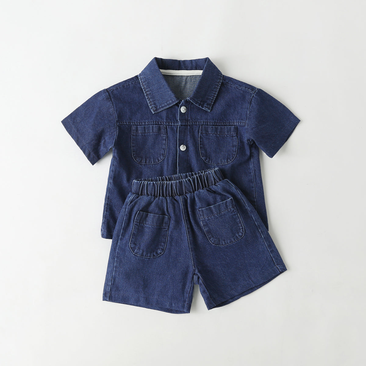 Baby wearing a solid color button front denim shirt and shorts set in blue, perfect for summer outings.