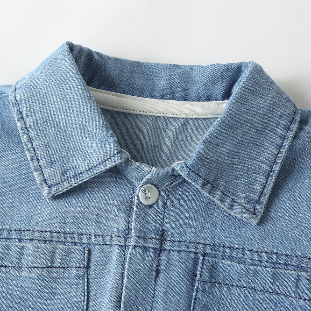 Baby wearing a solid color button front denim shirt and shorts set in blue, perfect for summer outings.