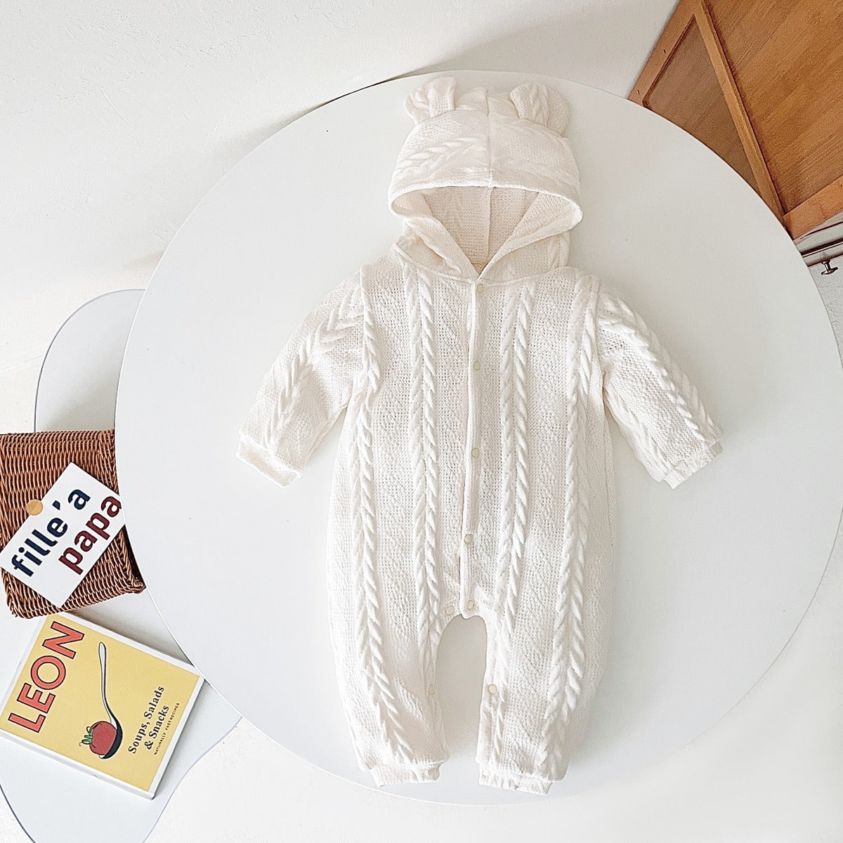 A cozy baby romper featuring a solid crochet-knitted pattern in white and brown, perfect for both baby girls and boys.
