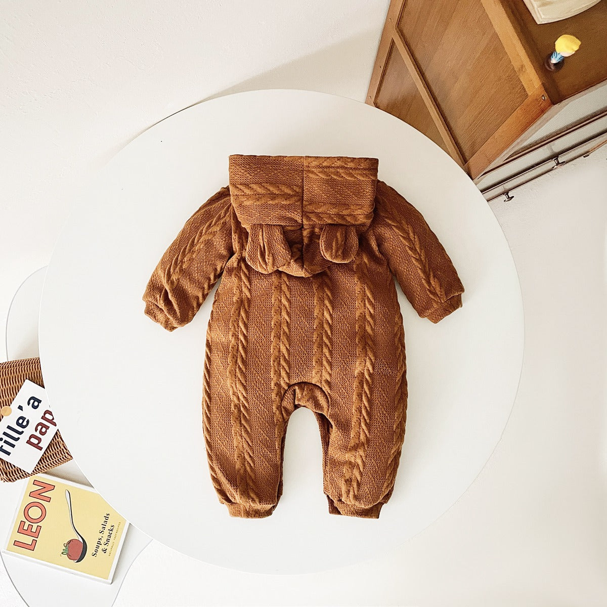 A cozy baby romper featuring a solid crochet-knitted pattern in white and brown, perfect for both baby girls and boys.