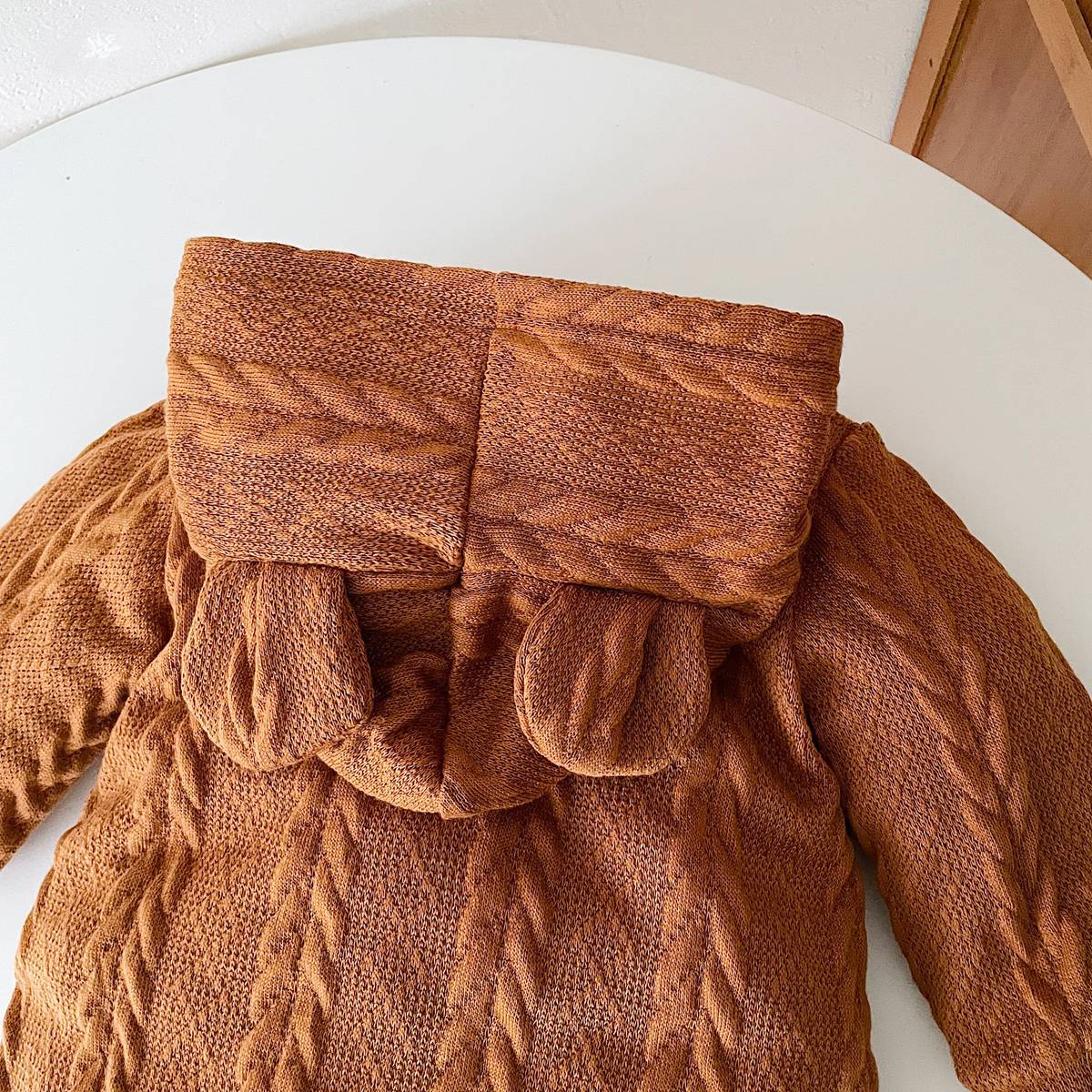 A cozy baby romper featuring a solid crochet-knitted pattern in white and brown, perfect for both baby girls and boys.