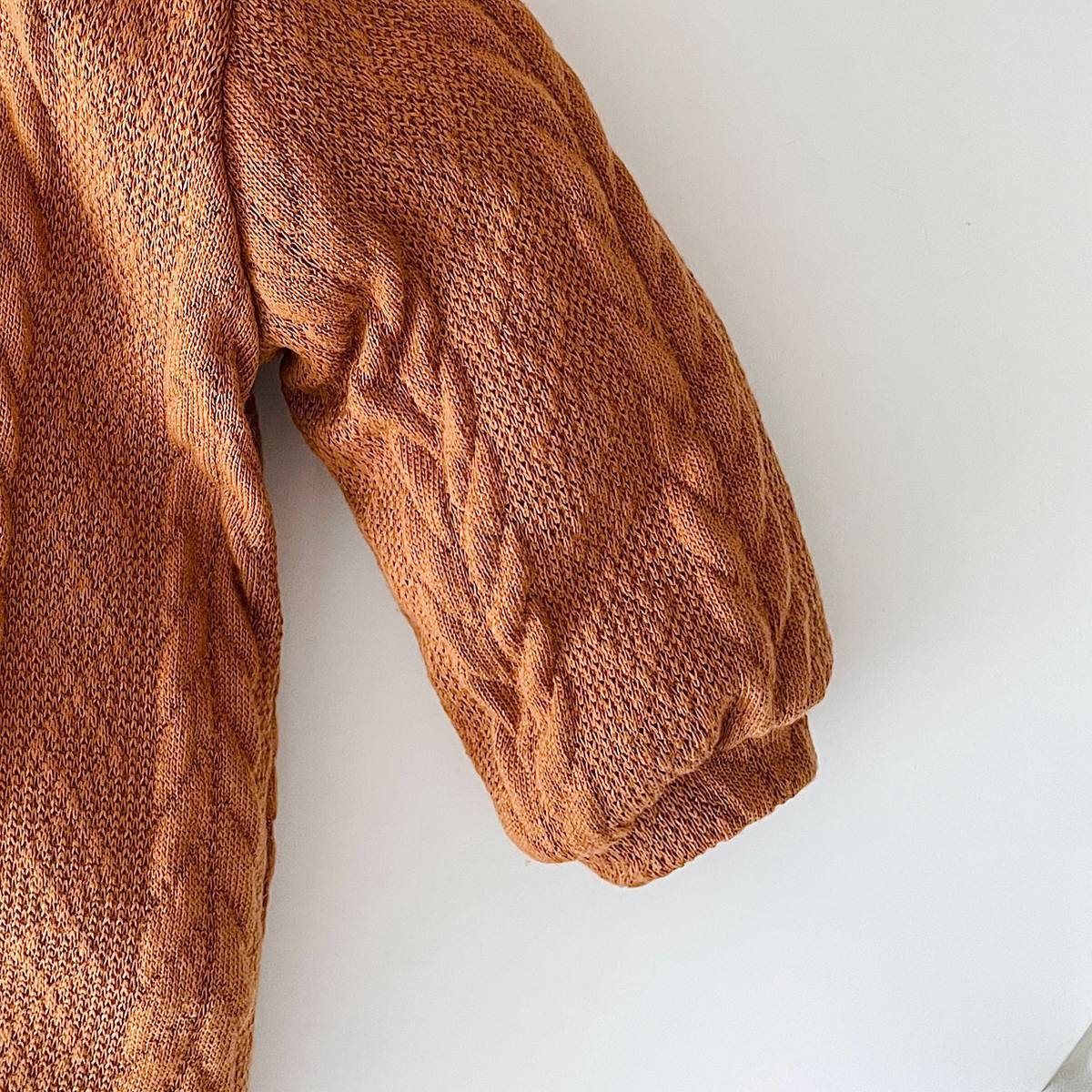 A cozy baby romper featuring a solid crochet-knitted pattern in white and brown, perfect for both baby girls and boys.