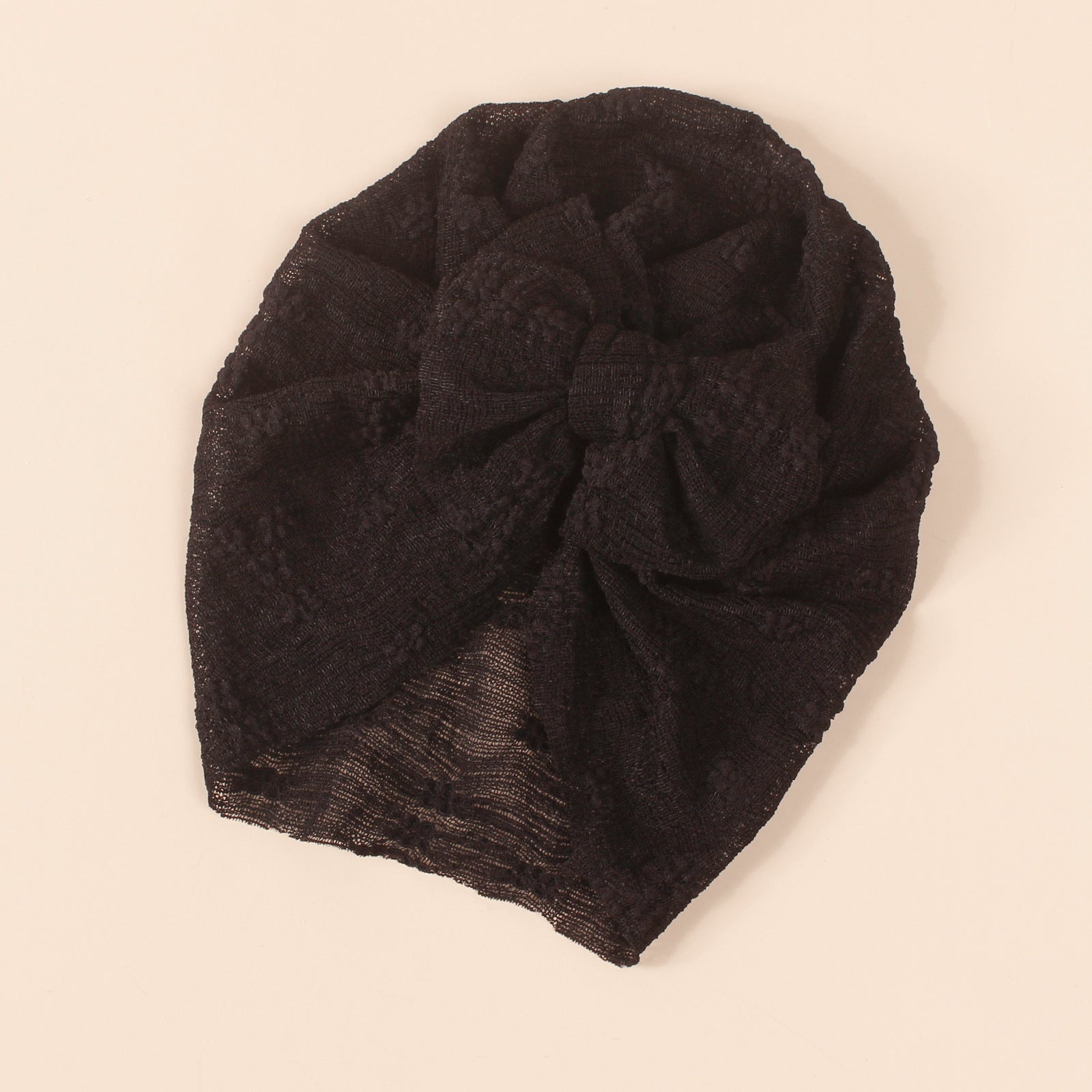 A collection of baby hats in solid colors including white, pink, blue, green, and beige, showcasing their elastic fit and breathable cotton material.