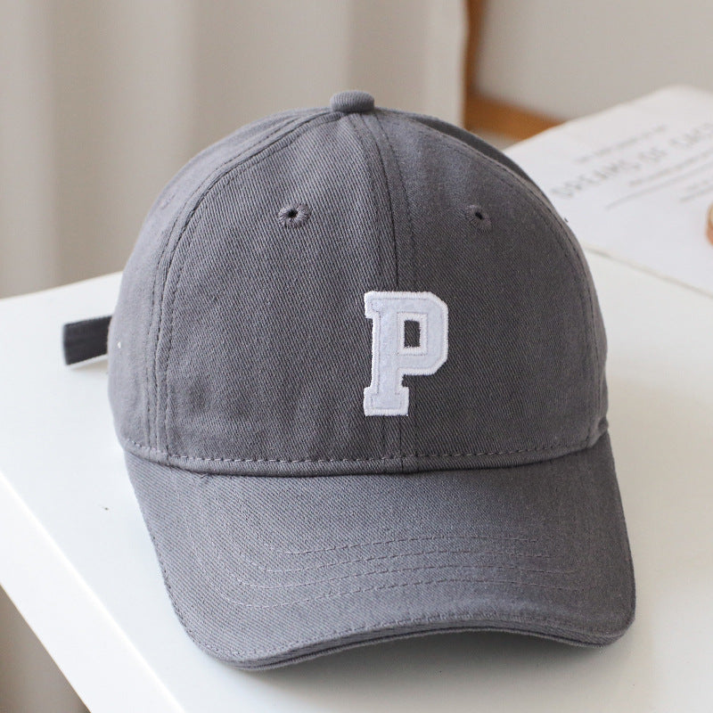 Baby wearing a solid color embroidered baseball hat, showcasing its stylish design and sun protection features.