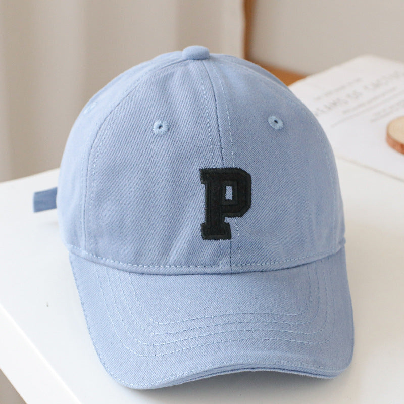 Baby wearing a solid color embroidered baseball hat, showcasing its stylish design and sun protection features.