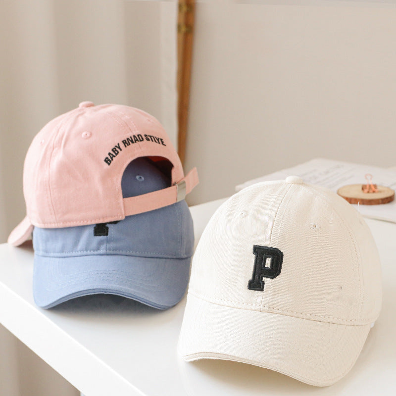 Baby wearing a solid color embroidered baseball hat, showcasing its stylish design and sun protection features.