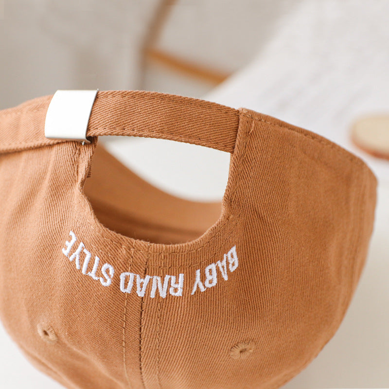 Baby wearing a solid color embroidered baseball hat, showcasing its stylish design and sun protection features.