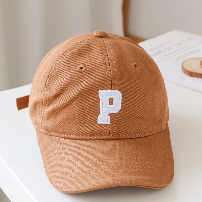 Baby wearing a solid color embroidered baseball hat, showcasing its stylish design and sun protection features.