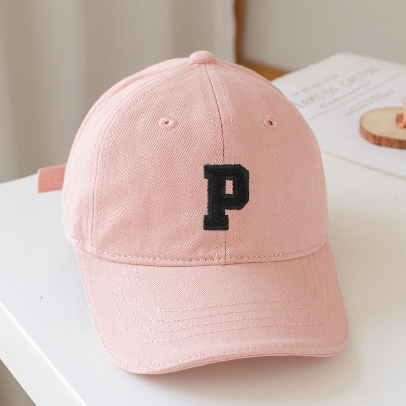 Baby wearing a solid color embroidered baseball hat, showcasing its stylish design and sun protection features.