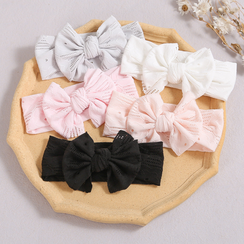 A stylish baby headband featuring a hollow out design and a bow tie, available in multiple colors including white, pink, and grey.