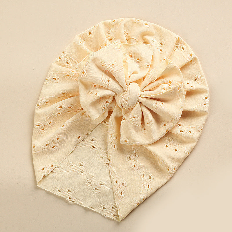 A collection of soft cotton baby caps in various colors with lace trim, perfect for keeping babies cool and stylish.