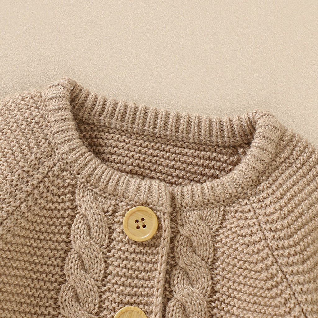 A beautifully handmade baby cardigan in solid colors, showcasing its long sleeves and soft cotton texture, perfect for infants.