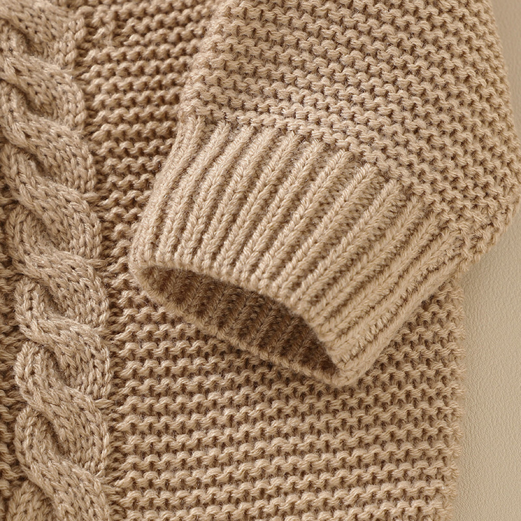 A beautifully handmade baby cardigan in solid colors, showcasing its long sleeves and soft cotton texture, perfect for infants.