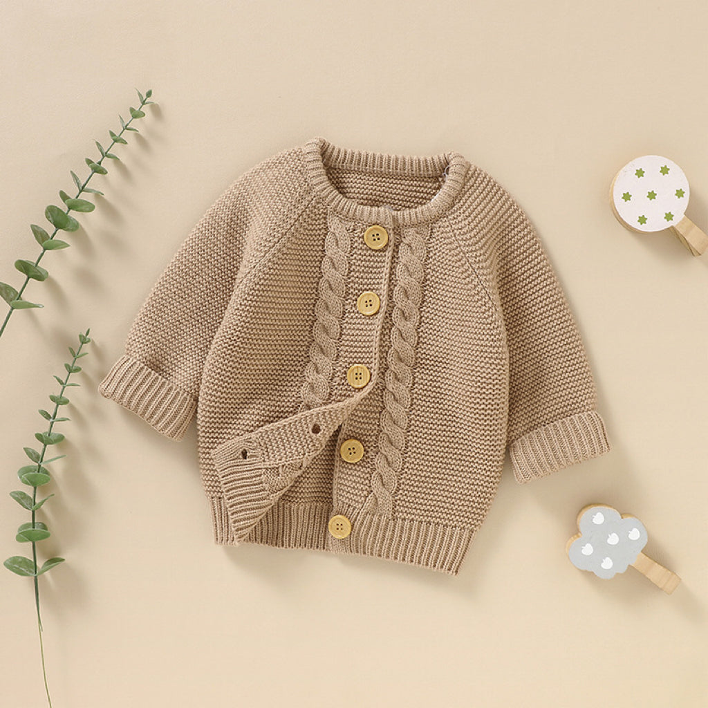 A beautifully handmade baby cardigan in solid colors, showcasing its long sleeves and soft cotton texture, perfect for infants.