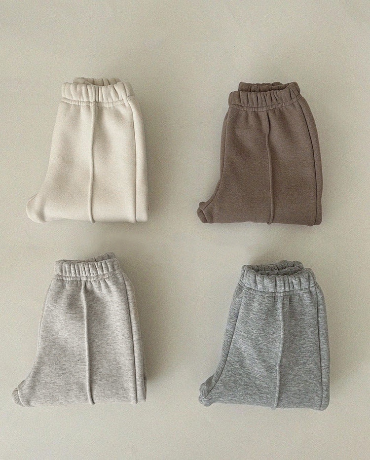A pair of baby sweatpants in solid colors, showcasing soft fleece material, perfect for autumn wear.