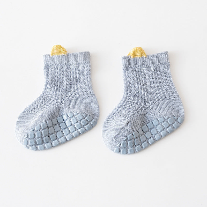 A pair of baby solid color non-slip toddler socks in a thin style, designed for summer with silicone grip bottoms for safety.