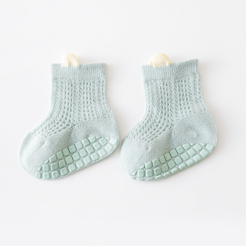 A pair of baby solid color non-slip toddler socks in a thin style, designed for summer with silicone grip bottoms for safety.