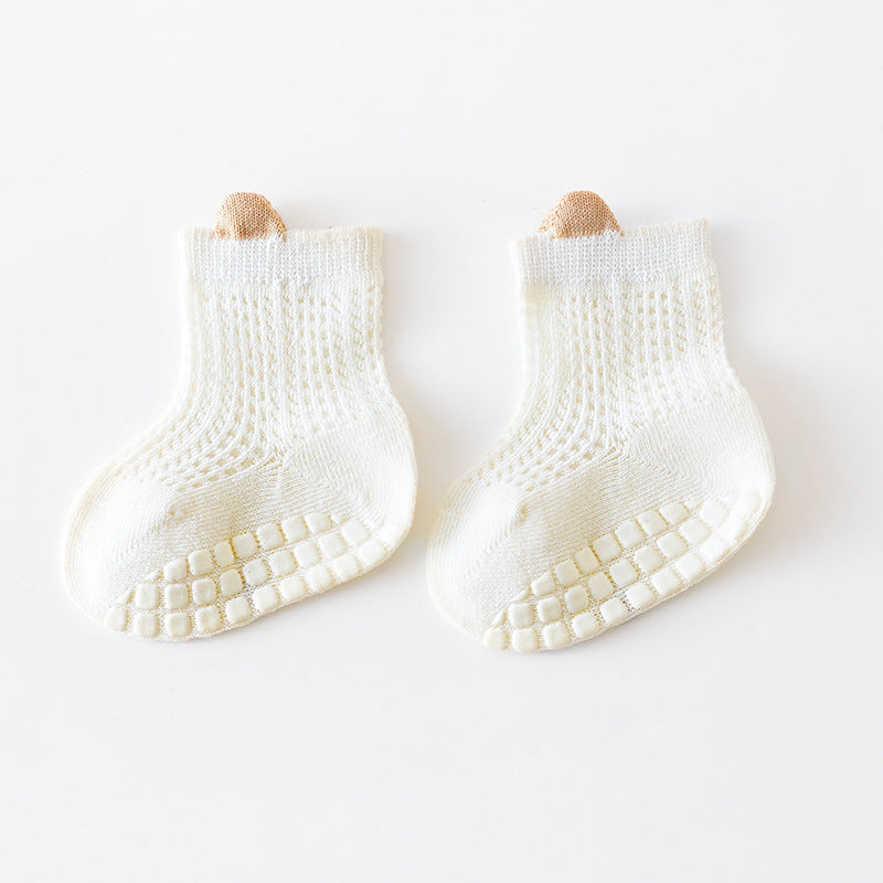 A pair of baby solid color non-slip toddler socks in a thin style, designed for summer with silicone grip bottoms for safety.