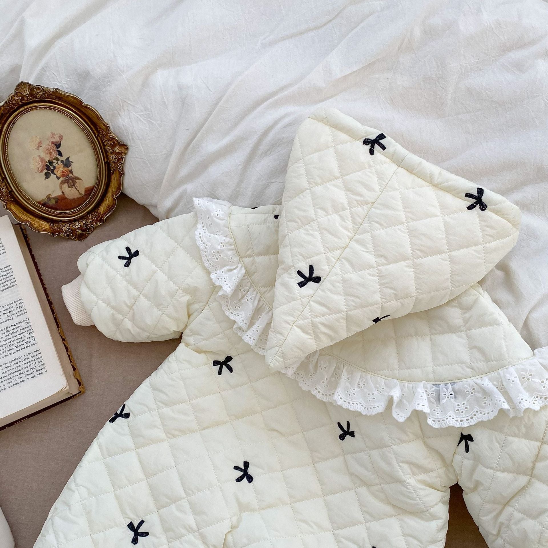 Baby toddler girl wearing a beige long sleeve outfit with bowknot design, perfect for winter.