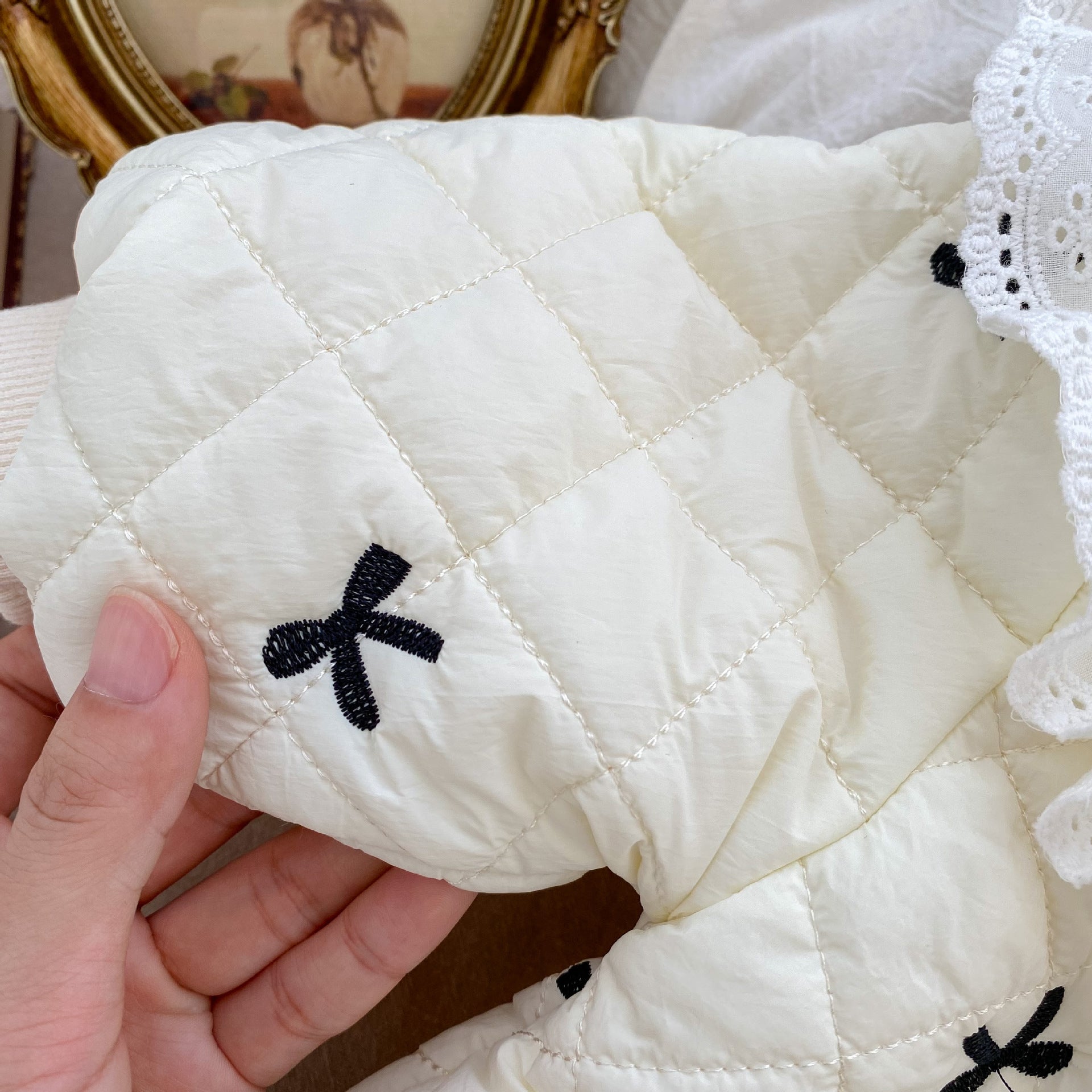 Baby toddler girl wearing a beige long sleeve outfit with bowknot design, perfect for winter.