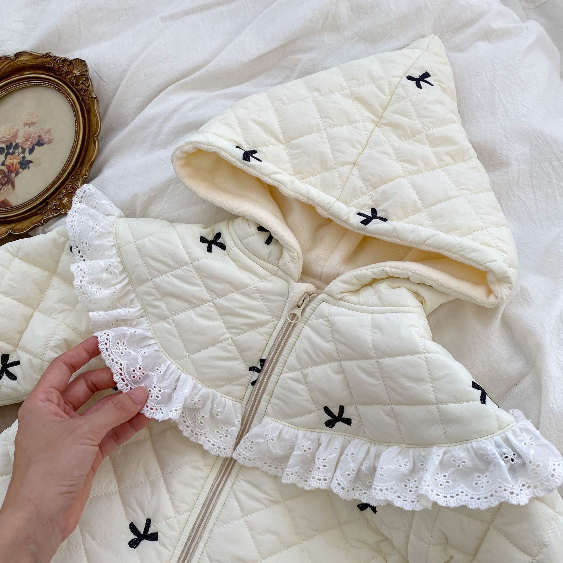 Baby toddler girl wearing a beige long sleeve outfit with bowknot design, perfect for winter.